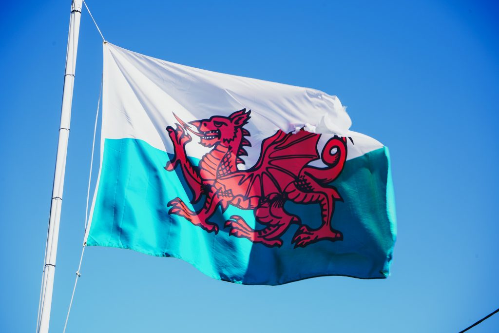 Wales flagga som är vit och grön med en röd drake i mitten.