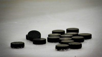 Ishockeypuckar som ligger på isen.